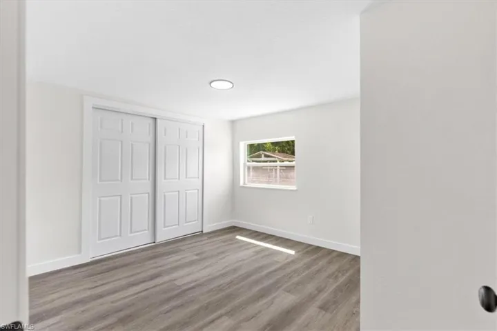 Unfurnished bedroom with a closet and hardwood / wood-style floors