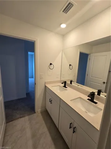 2nd Bathroom with double vanity and tile patterned flooring