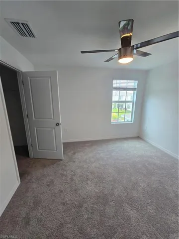 1st  bedroom with carpet flooring and ceiling fan
