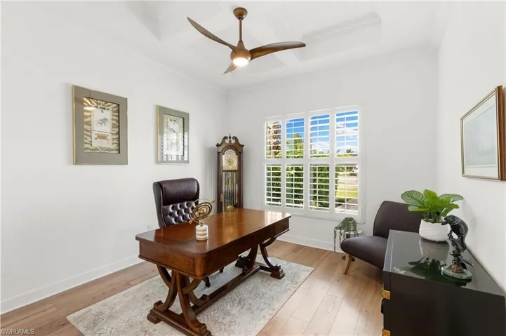Office featuring coffered ceiling, light wood-style flooring, a ceiling fan, crown molding, and beam ceiling