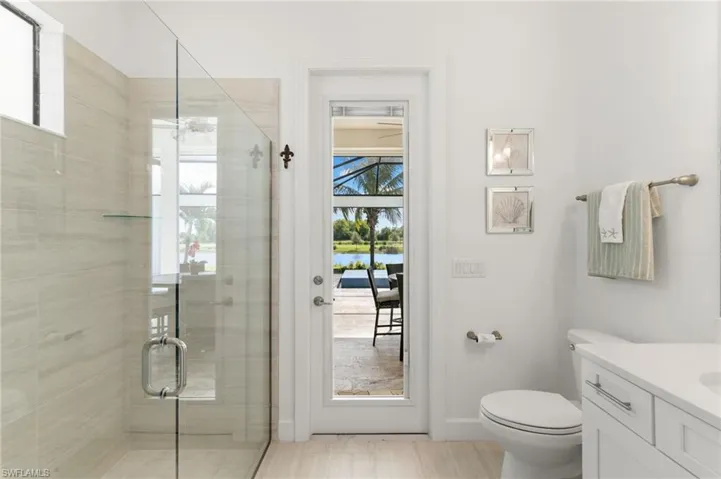 Bathroom featuring healthy amount of natural light, a stall shower, vanity, and a water view