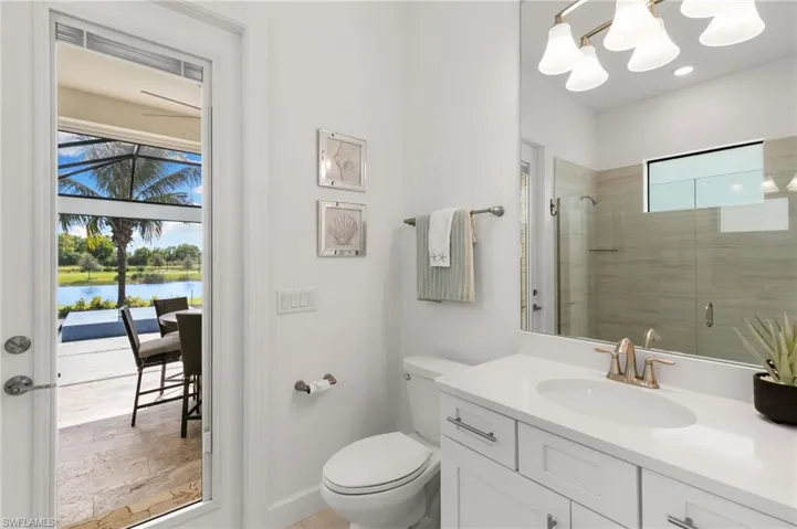 Bathroom with a shower stall, vanity, and a water view