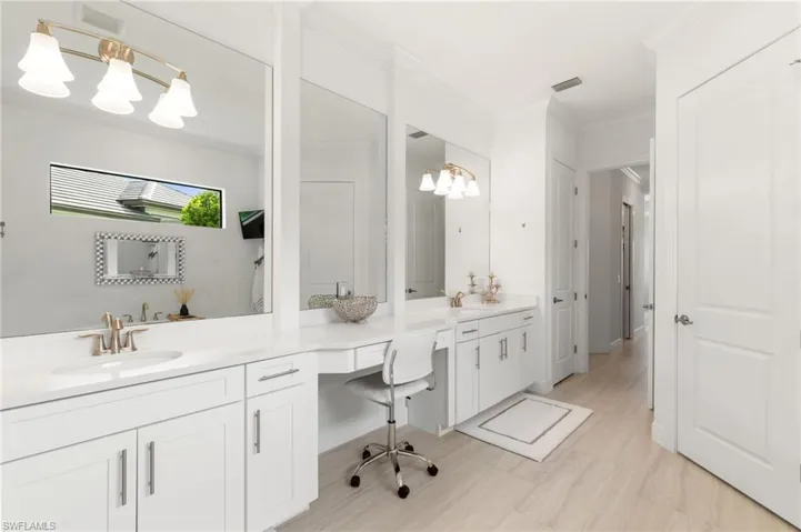 Full bathroom with ornamental molding, a chandelier, and double vanity