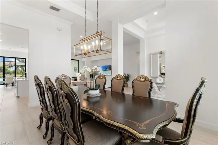 Dining room with recessed lighting, crown molding, and a chandelier