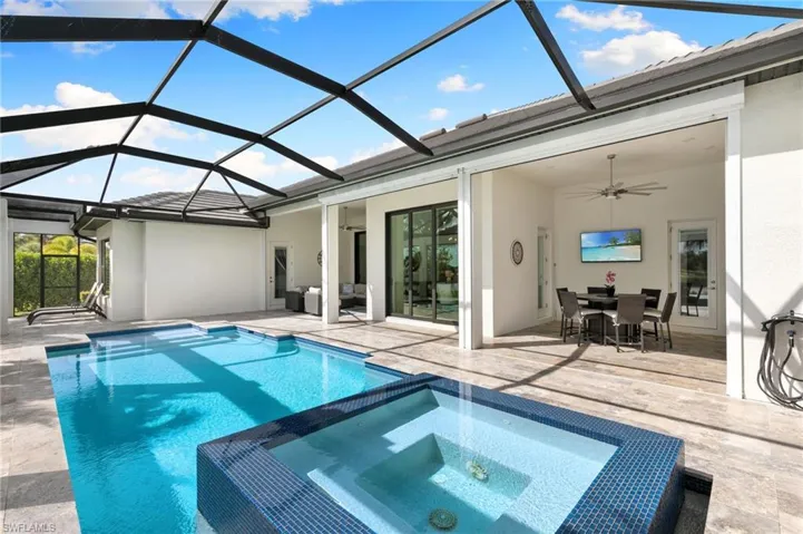 View of swimming pool with a patio area, a sunroom, a ceiling fan, and a pool with connected hot tub