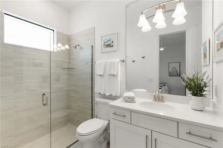 Bathroom featuring a stall shower, a chandelier, and vanity