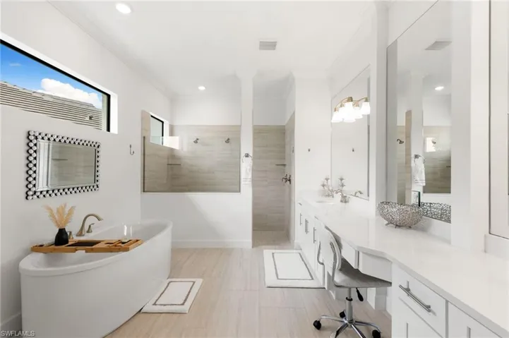 Full bathroom featuring a walk in shower, crown molding, a soaking tub, vanity, and recessed lighting