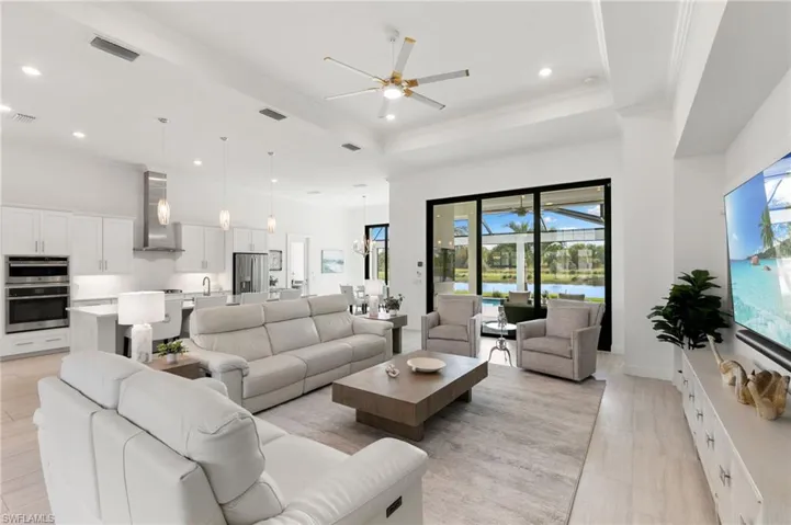 Living area with ceiling fan, recessed lighting, crown molding, and a raised ceiling