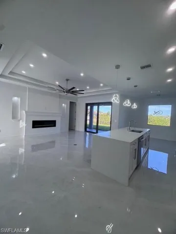Kitchen featuring marble finish floor, dishwashing machine, a sink, and visible vents