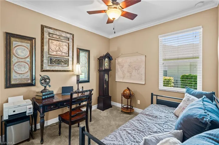 Bedroom featuring carpet, ornamental molding, baseboards, multiple windows, and a desk