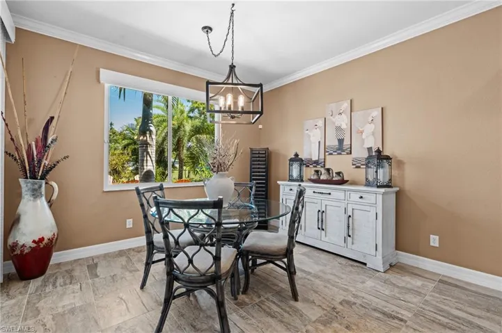 Dining room featuring a chandelier, ornamental molding, and baseboards