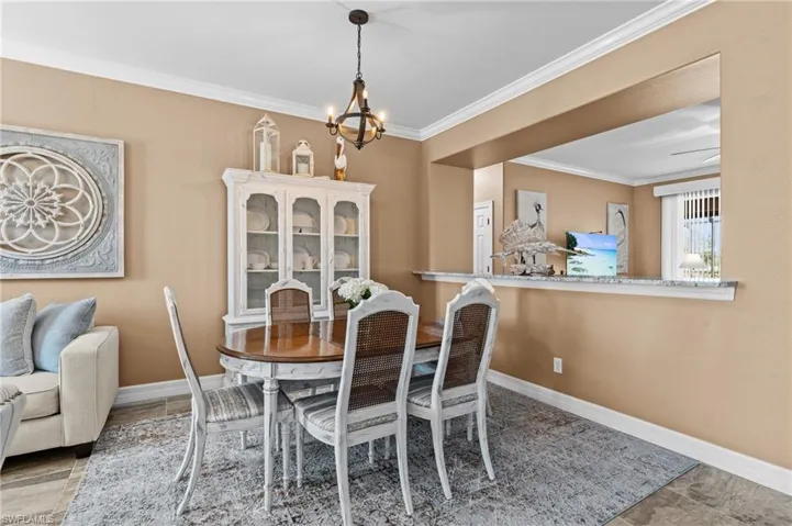 Dining room with a chandelier, ornamental molding, and baseboards