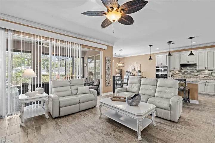 Living room with crown molding, a ceiling fan, baseboards, and recessed lighting