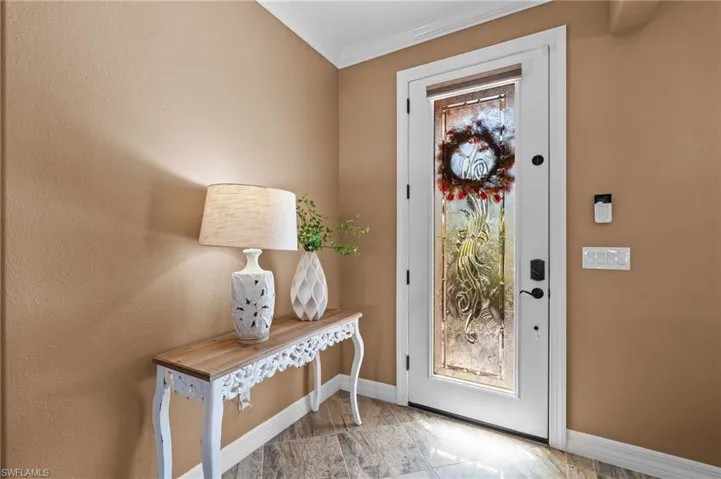 Foyer with baseboards and ornamental molding