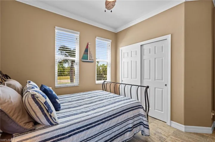 Bedroom with baseboards, crown molding, a closet, and a ceiling fan