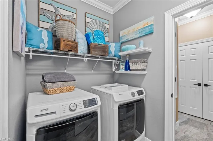 Laundry area featuring crown molding, independent washer and dryer, and baseboards