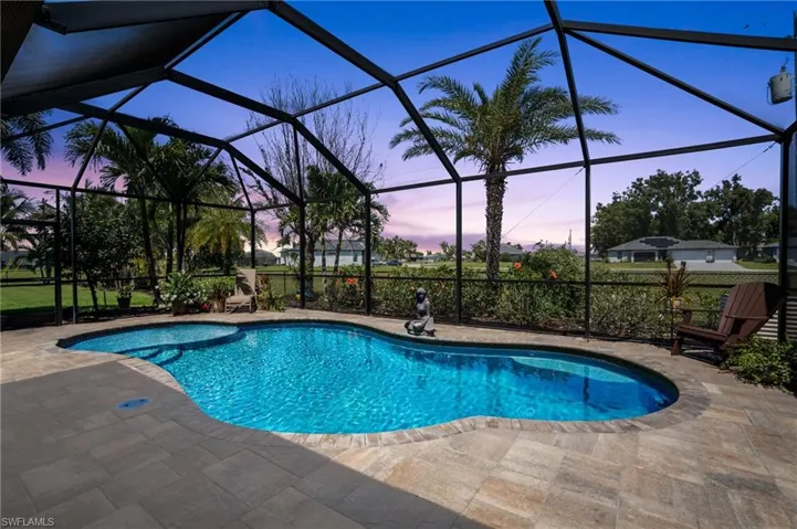 Pool at dusk with a patio area, an outdoor pool, and a lanai