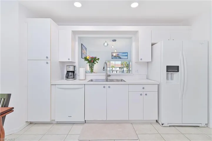 Kitchen with white appliances, light countertops, white cabinetry, recessed lighting, and light tile patterned floors
