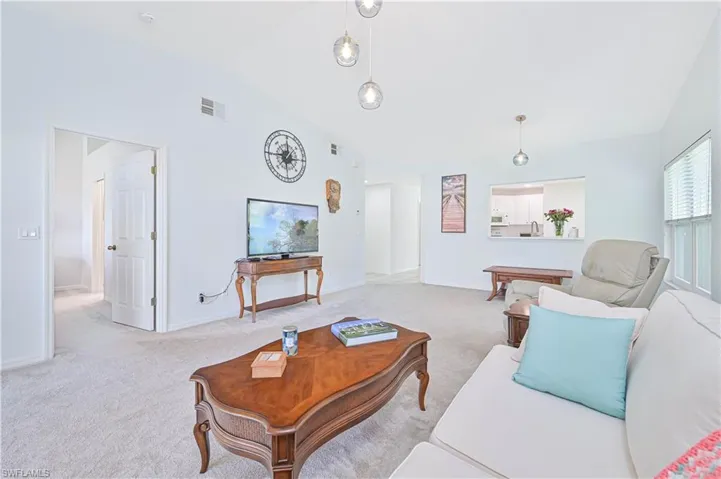 Living room with carpet floors and vaulted ceiling
