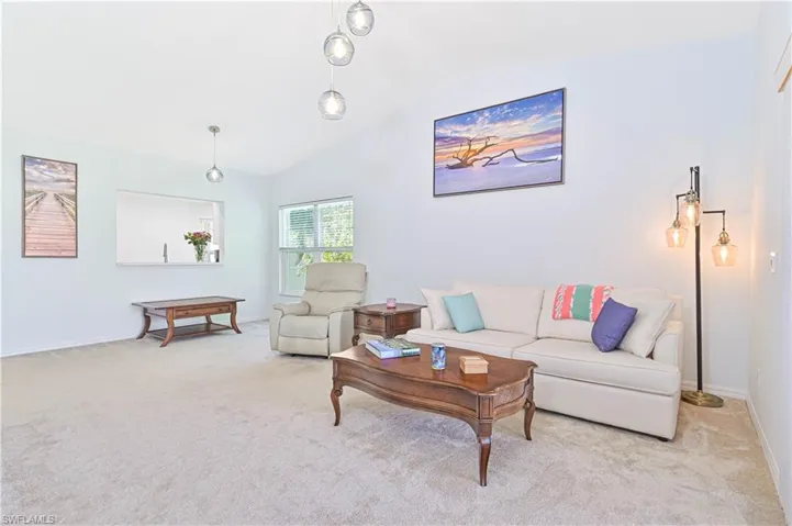 Living room with light carpet and vaulted ceiling