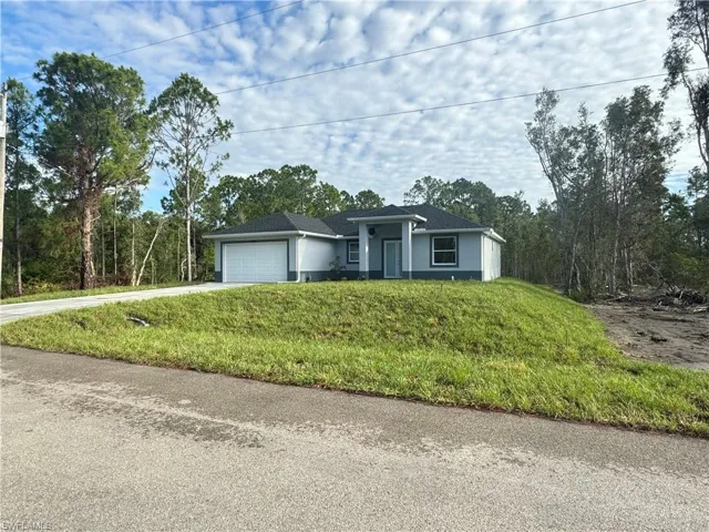 View of front of property with a garage and a front yard