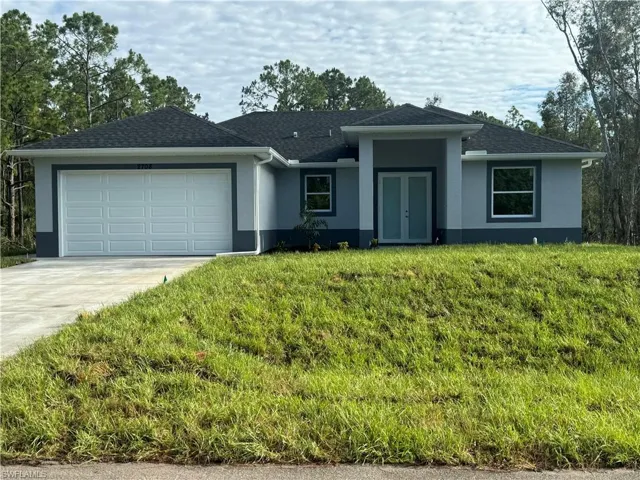 Single story home featuring a front yard and a garage