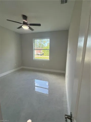 Spare room featuring ceiling fan and light tile flooring