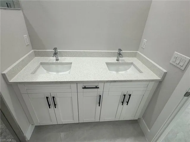 Bathroom with tile flooring and double sink vanity