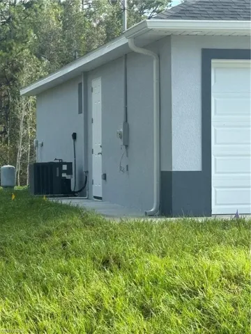 View of home's exterior featuring a yard and central AC unit