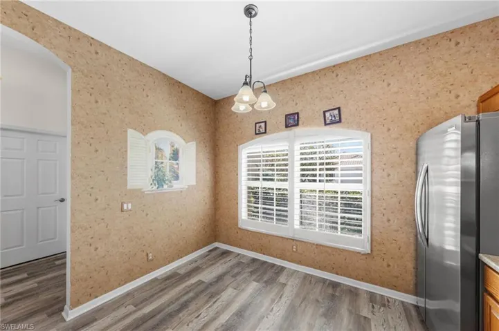 Unfurnished dining area with light wood-type flooring and wallpapered walls