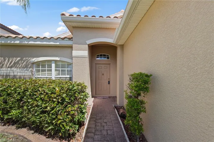 Property entrance featuring stucco siding and a tiled roof