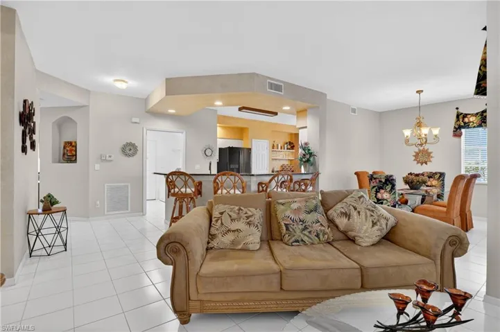 Living area featuring recessed lighting, light tile patterned floors, and a chandelier