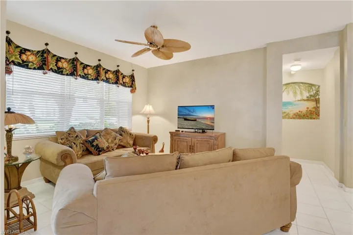 Living room with light tile patterned floors and ceiling fan