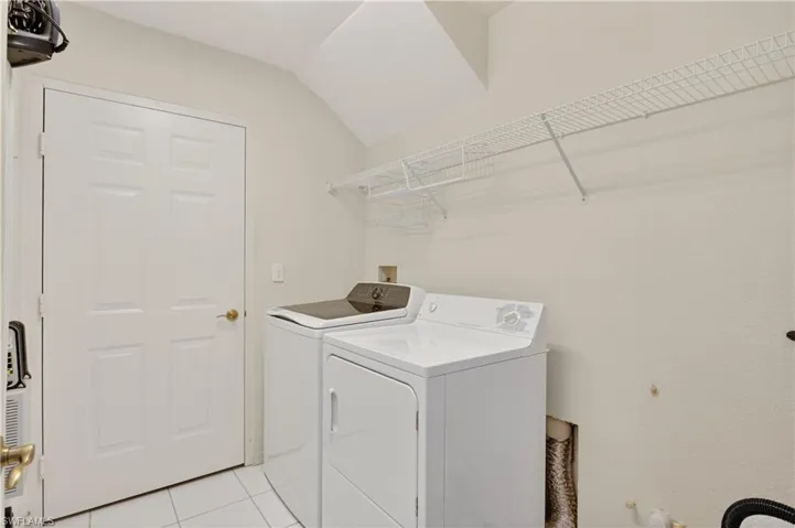 Laundry room with light tile patterned floors and washer hookup