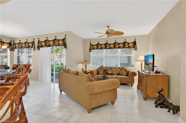 Living area featuring light tile patterned flooring and a ceiling fan