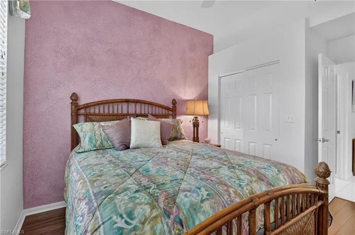 Bedroom featuring a closet, wood finished floors, a ceiling fan, and a textured wall