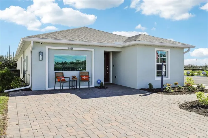 MODEL. Exterior elevation featuring a light blue stucco finish, a gray shingle roof, a paver driveway, and contemporary exterior lighting fixtures