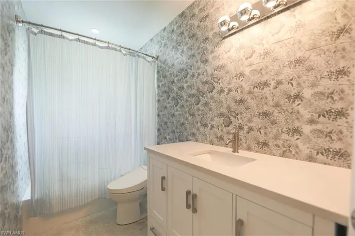 Full bathroom with vanity, toilet, and shower / tub combo