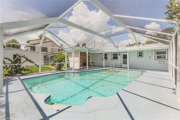 View of swimming pool featuring a patio and glass enclosure
