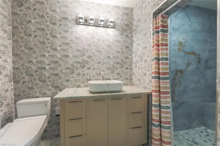 Bathroom featuring vanity, a shower with shower curtain, and toilet