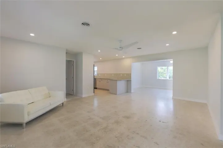 Unfurnished living room featuring ceiling fan