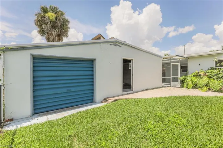 Rear view of house with a garage and a yard