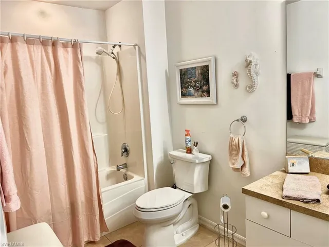 Full bathroom featuring vanity, toilet, tile patterned floors, and shower / tub combo