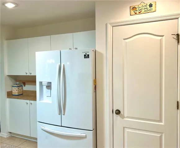 Kitchen featuring white Coffee Station next  to refrigerator-freezer  with ice dispenser on door and light tile patterned flooring