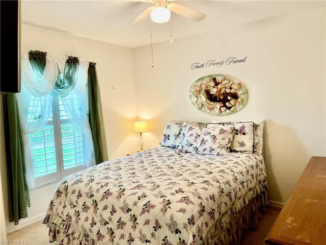 Bedroom featuring ceiling fan and plantation shutters