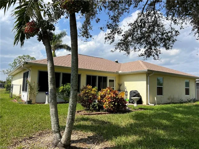 Back of house with a yard