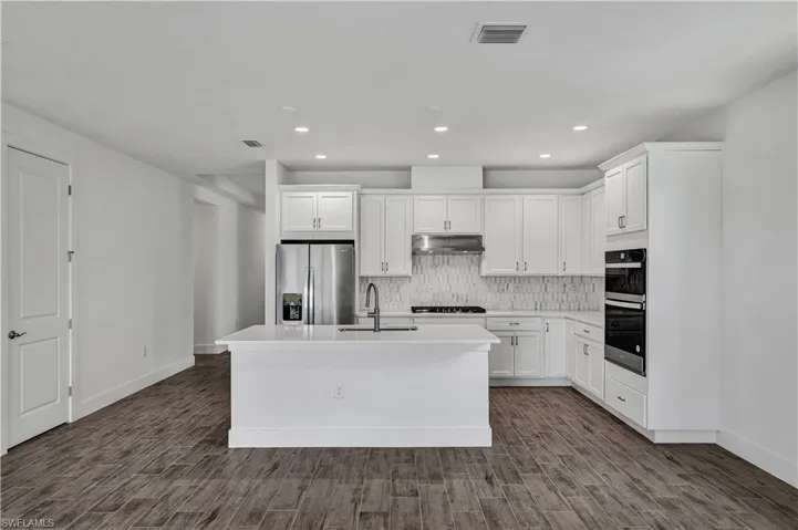 Kitchen layout with stainless steel appliances, ample cabinetry, and quartz countertops