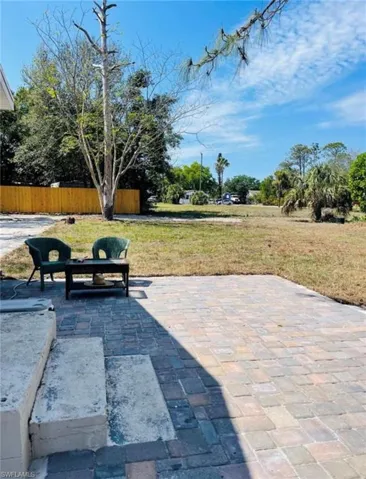 Spacious outdoor patio featuring multi-toned paver stones and concrete steps