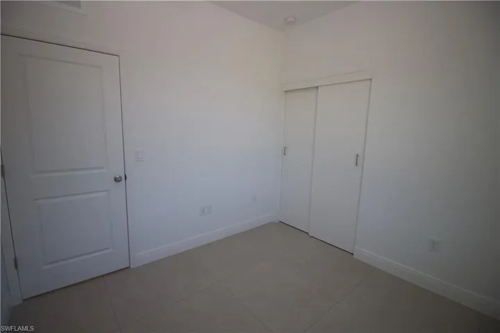 Bedroom featuring light tile patterned flooring and a closet