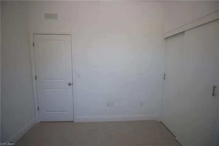 Bedroom featuring light tile patterned flooring and a closet